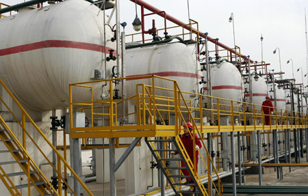 Workers of the No. one oil extracting unit of the Changqing oilfield inspect oil tanks in Yan'an, northwest China's Shaanxi province, Dec. 16, 2007.(Xinhua/Tao Ming)